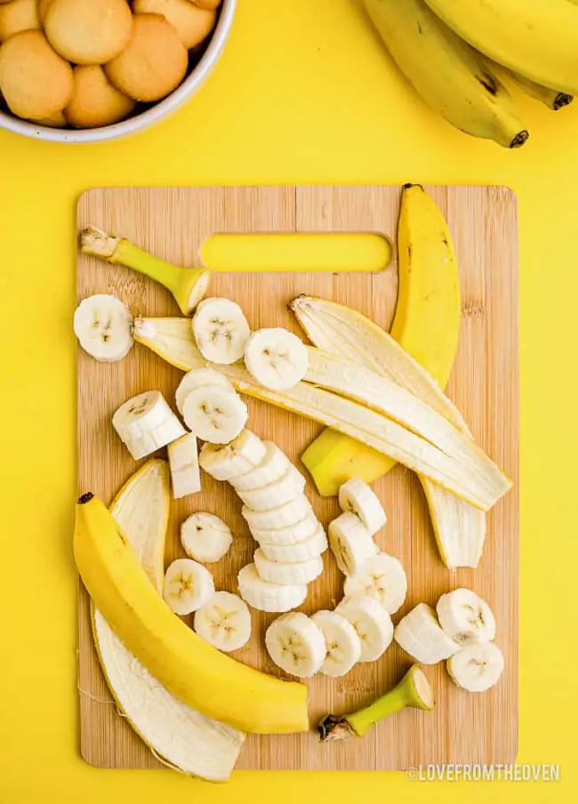 A banana cut up on a cutting board.