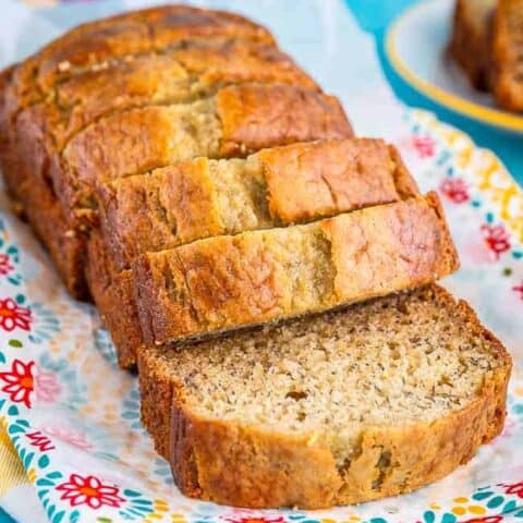 A loaf of bread on a floral towel and a blue background.