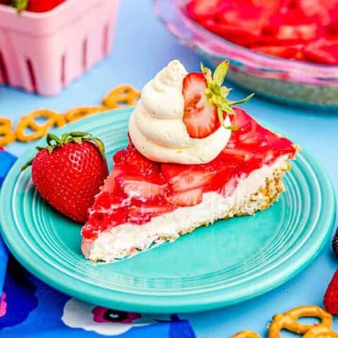 A slice of strawberry pretzel pie on a blue background.