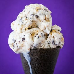 A close up of an ice cream cone with smores ice cream.