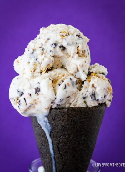 A close up of an ice cream cone with smores ice cream.