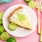 A slice of key lime pie on a plate on a pink background.