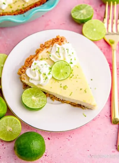 A slice of key lime pie on a plate on a pink background.