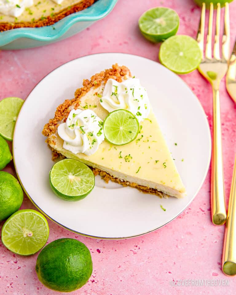 A slice of key lime pie on a plate on a pink background.
