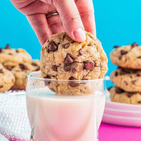 A cookie being dunked in milk.