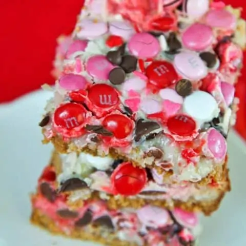 Magic cookie bars with pink and red mms on top.