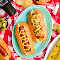 Two hot dogs in front of an air fryer.