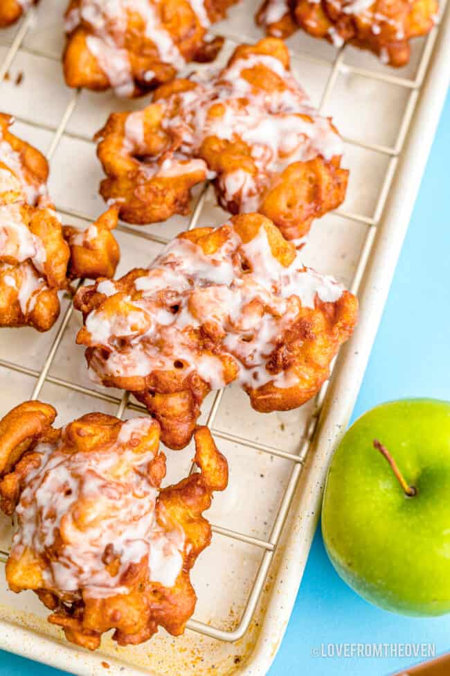 Apple fritters on a baking sheet.