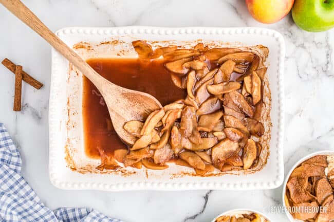 A white pan full of baked cinnamon apples. 