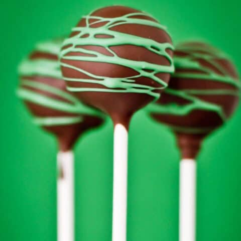 Chocolate cake pops in front of a green background.