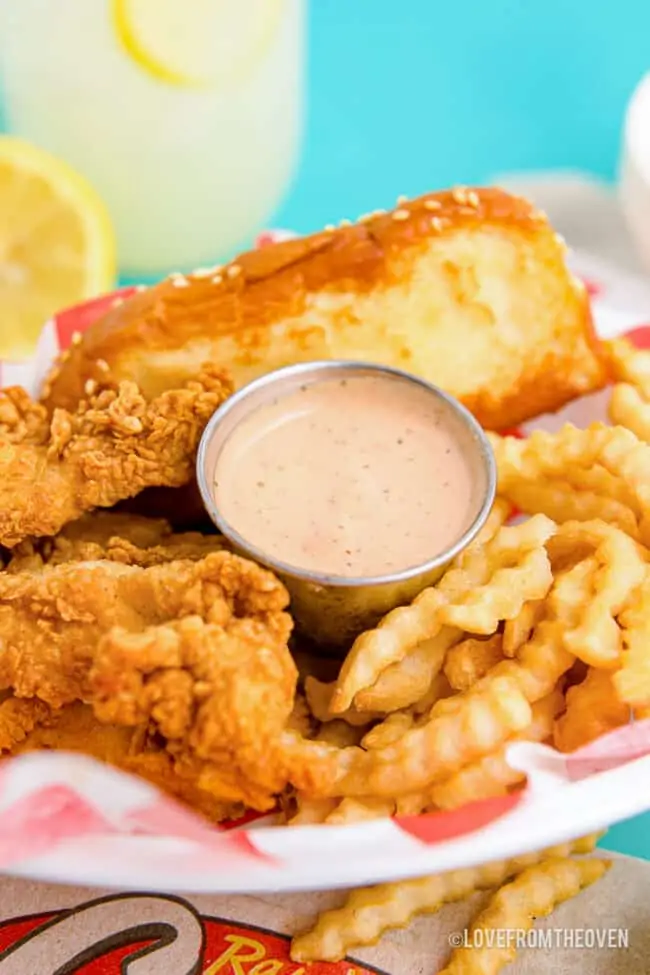 Photo of canes sauce with chicken and fries.
