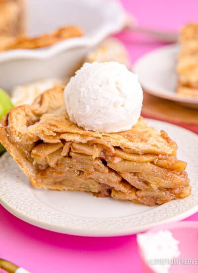 A slice of apple pie with vanilla ice cream on top.