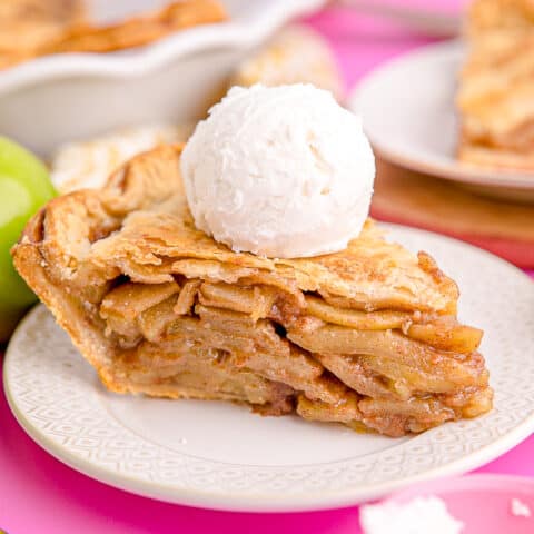 A slice of apple pie with vanilla ice cream on top.