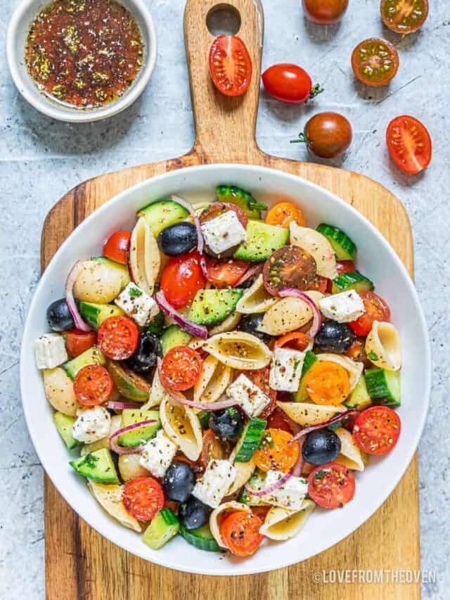 A bowl of pasta salad in a white bowl.