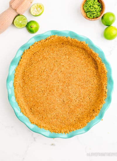 A graham cracker crust in a blue pie pan.