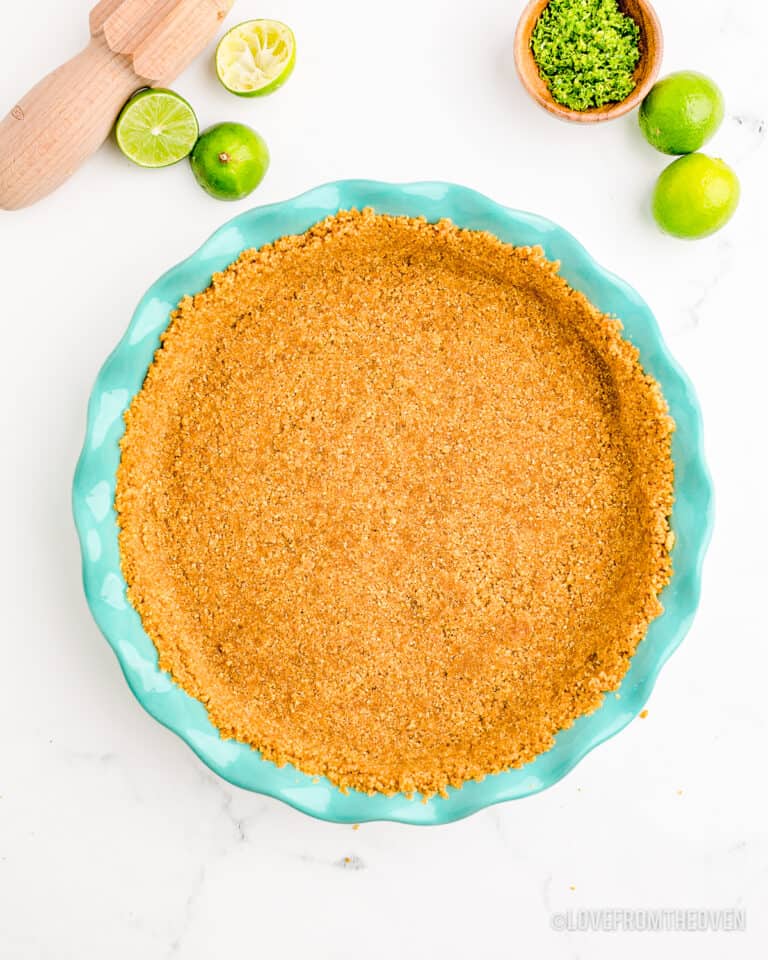 A graham cracker crust in a blue pie pan.