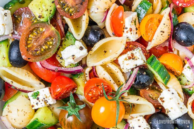 A close up photo of Greek pasta salad.