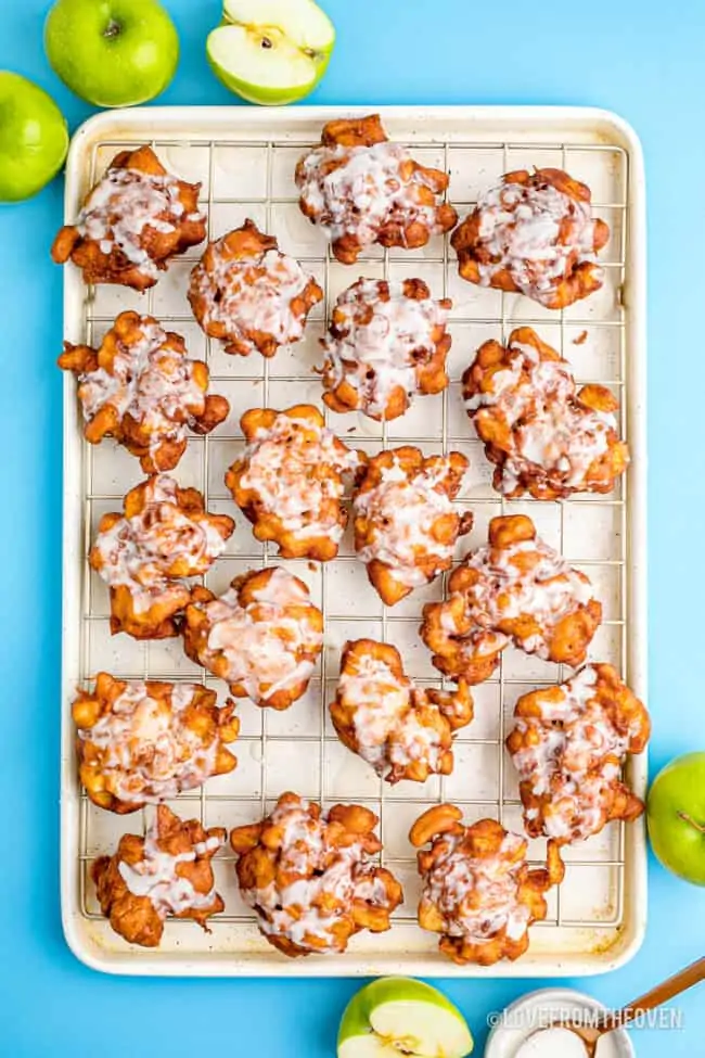 A baking tray full of homemade apple fritters.