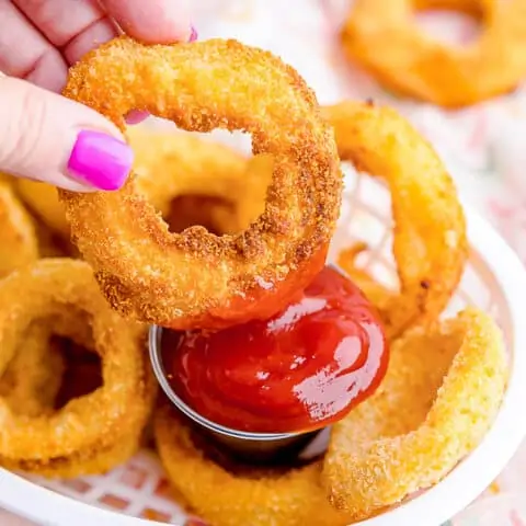 onion ring being dipped in ketchup