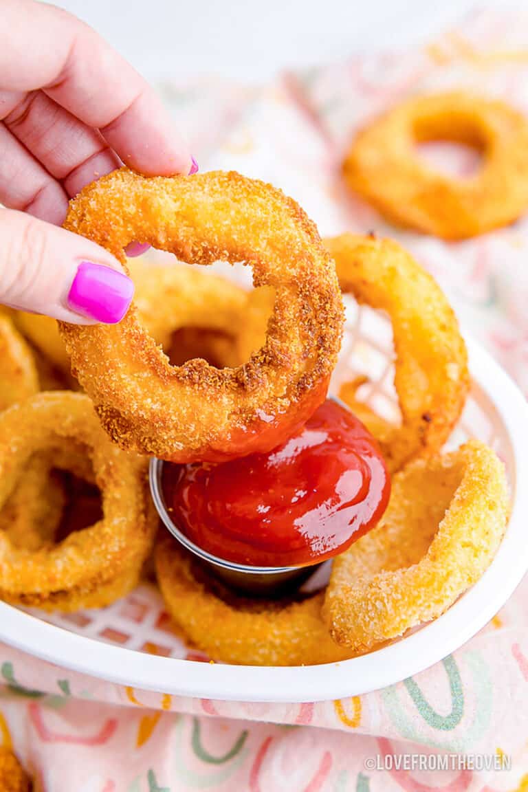 onion ring being dipped in ketchup