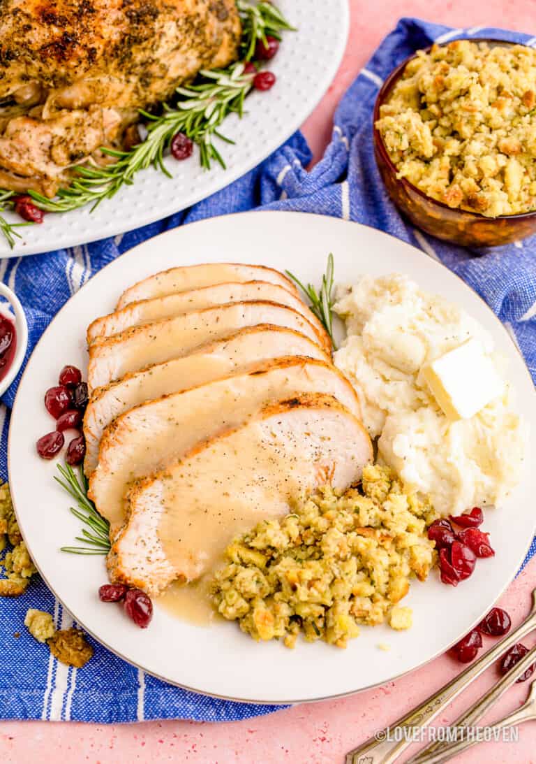Slices of turkey on a plate with sides and gravy.