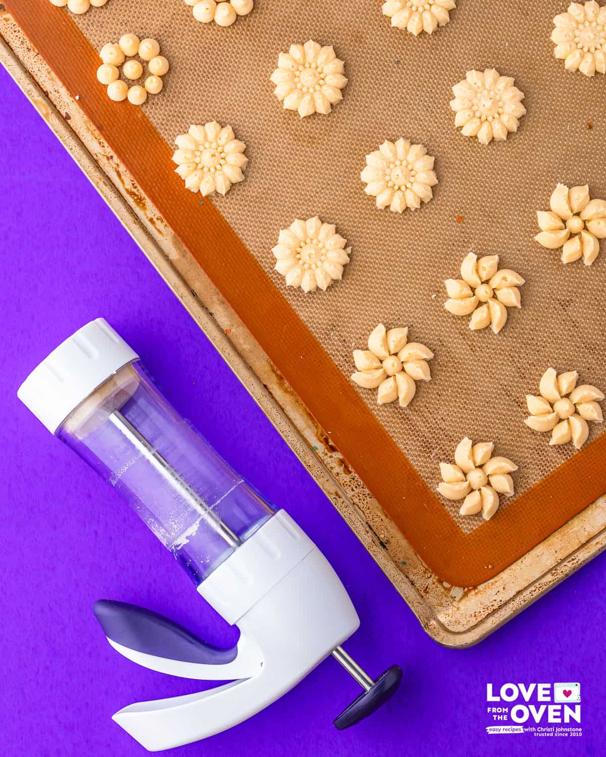 unbaked, pressed spritz cookies on a baking sheet