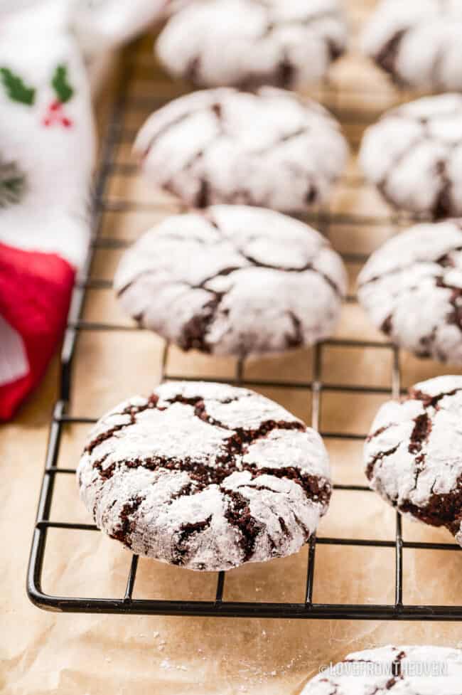 Chocolate crinkle cookies on a wire cooling rack.