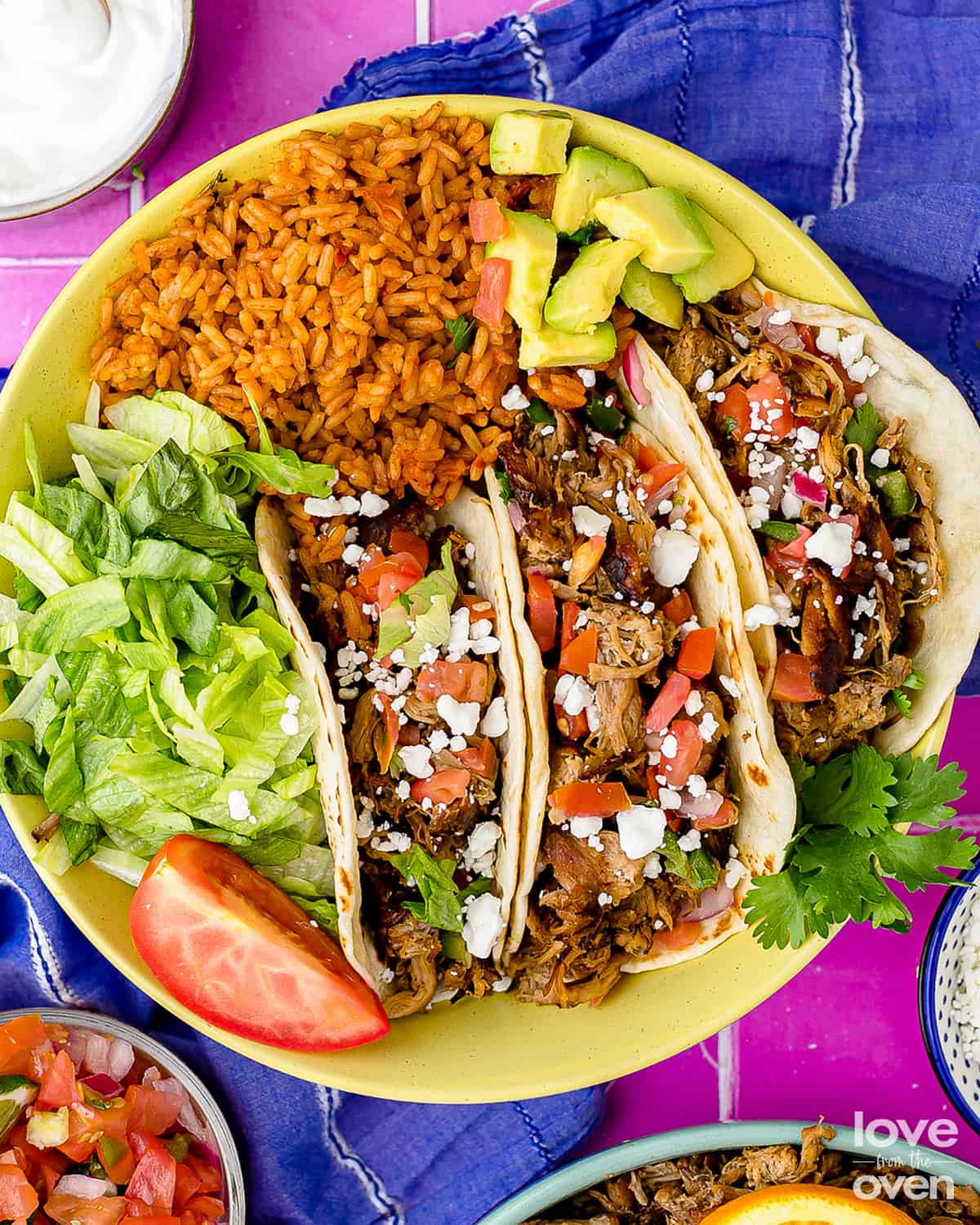 a plate of slow cooker pork carnitas on a blue napkin