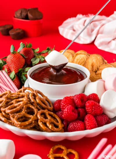 A bowl of chocolate fondue surrounded by fondue dippers