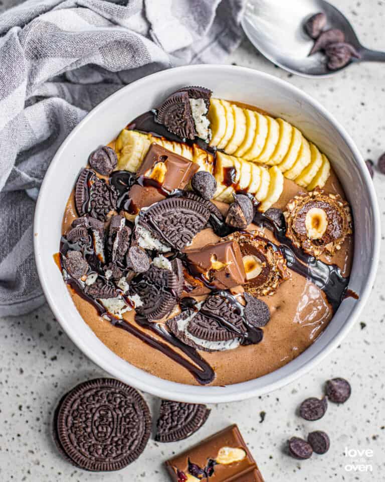 A chocolate smoothie bowl with bananas and toppings