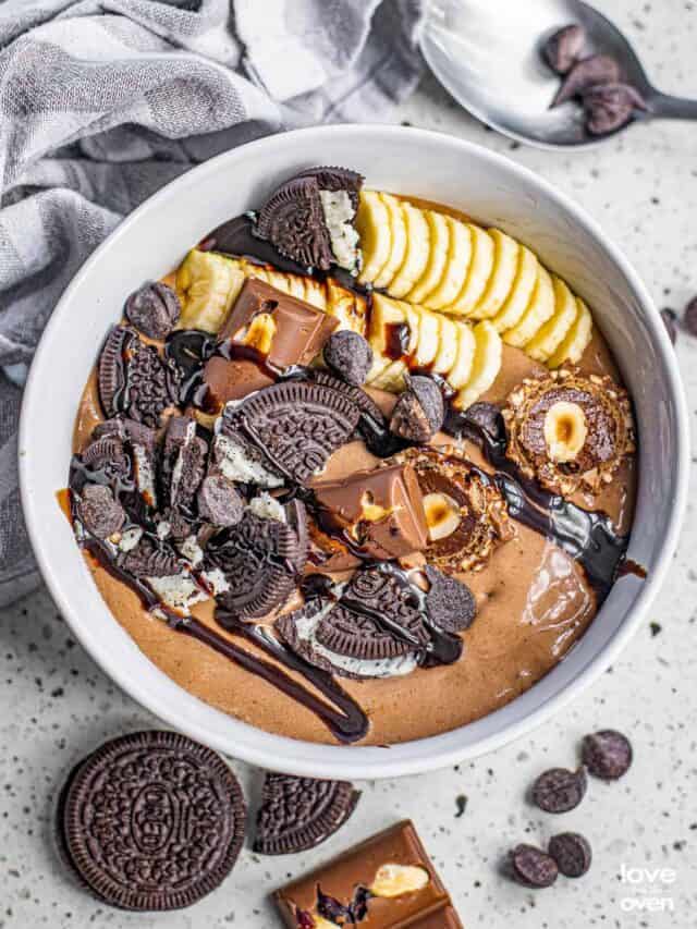 A chocolate smoothie bowl with bananas and toppings