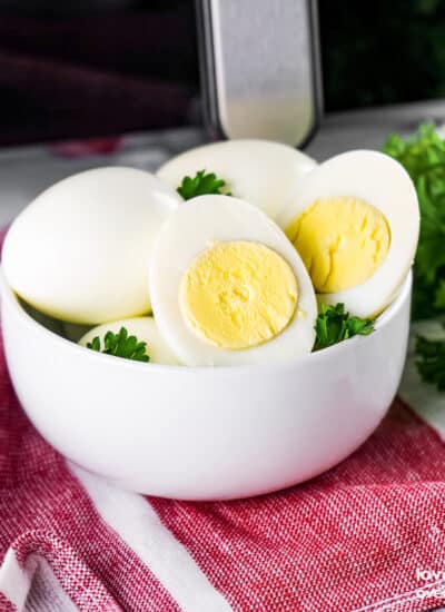 a bowl of hard boiled eggs in front of an air fryer