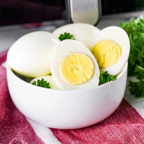a bowl of hard boiled eggs in front of an air fryer