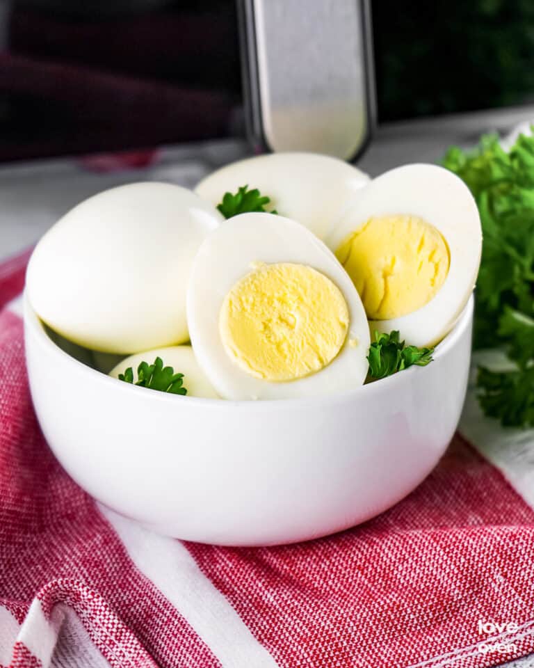 a bowl of hard boiled eggs in front of an air fryer