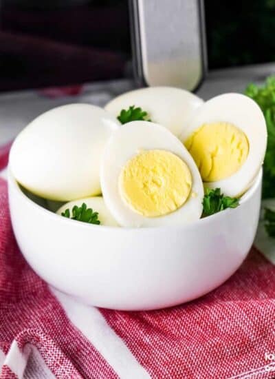 a bowl of hard boiled eggs in front of an air fryer