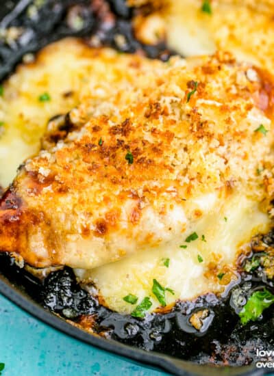 A copycat longhorn parmesan crusted chicken breast in a cast iron skillet