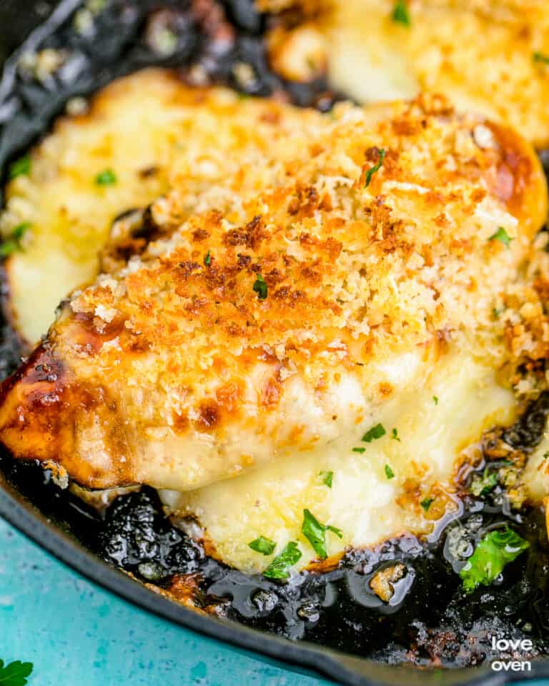 A copycat longhorn parmesan crusted chicken breast in a cast iron skillet