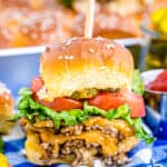 A cheeseburger slider on a blue and white tablecloth.