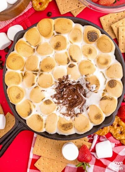 eaten smores dip in a cast iron pan on a colorful red table