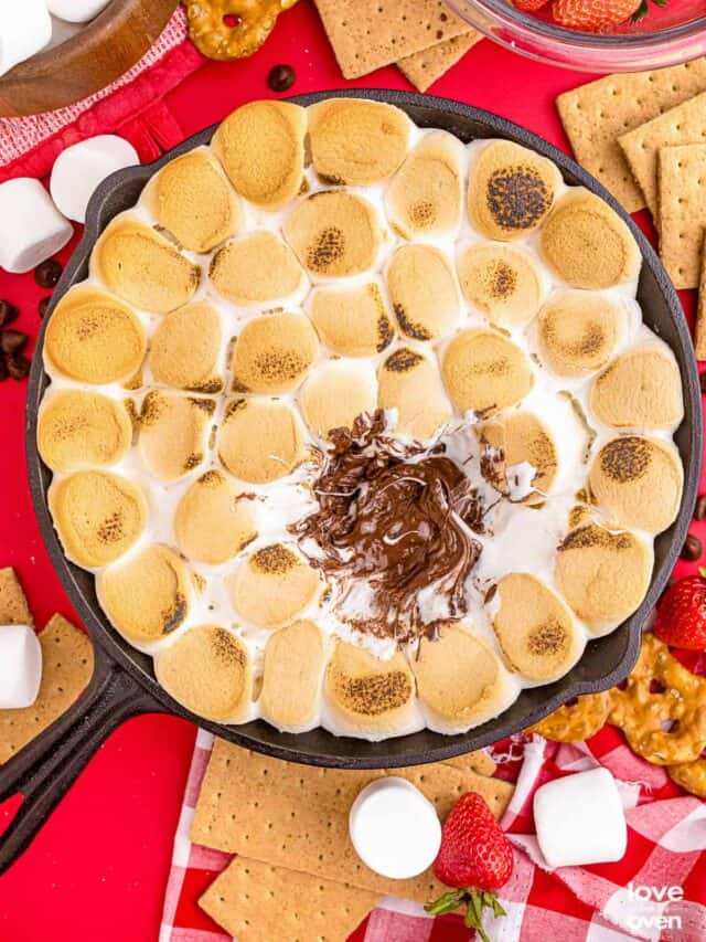 eaten smores dip in a cast iron pan on a colorful red table