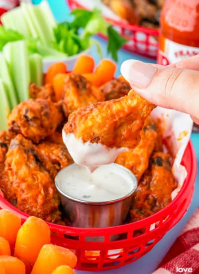 A basket full of frozen chicken wings that were made in the air fryer, with ranch dip.