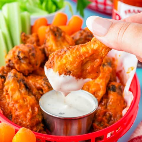 A basket full of frozen chicken wings that were made in the air fryer, with ranch dip.
