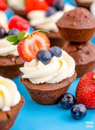 Brownie bites topped with frosting, and berries