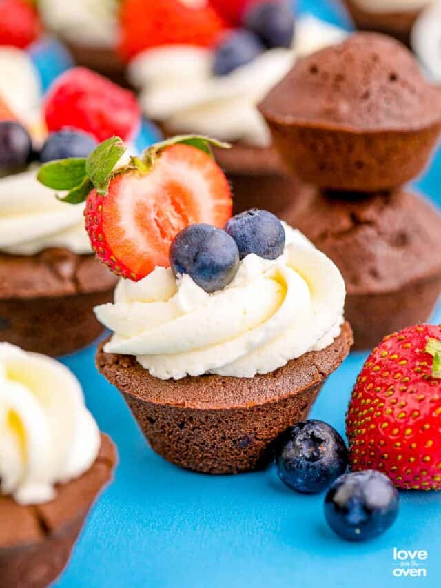 Brownie bites topped with frosting, and berries