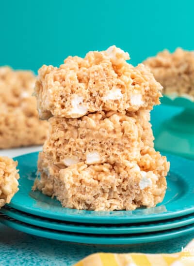 A stack of peanut butter rice krispies treats on blue plates.