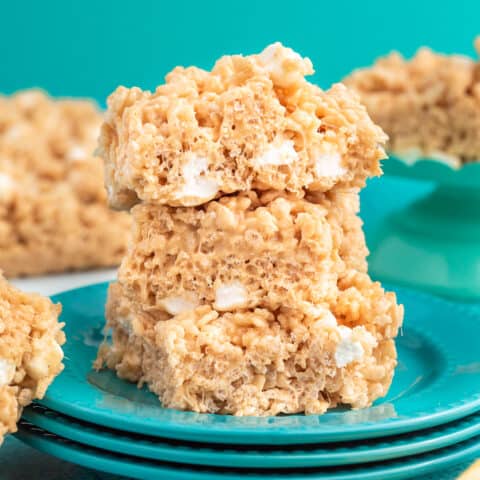A stack of peanut butter rice krispies treats on blue plates.