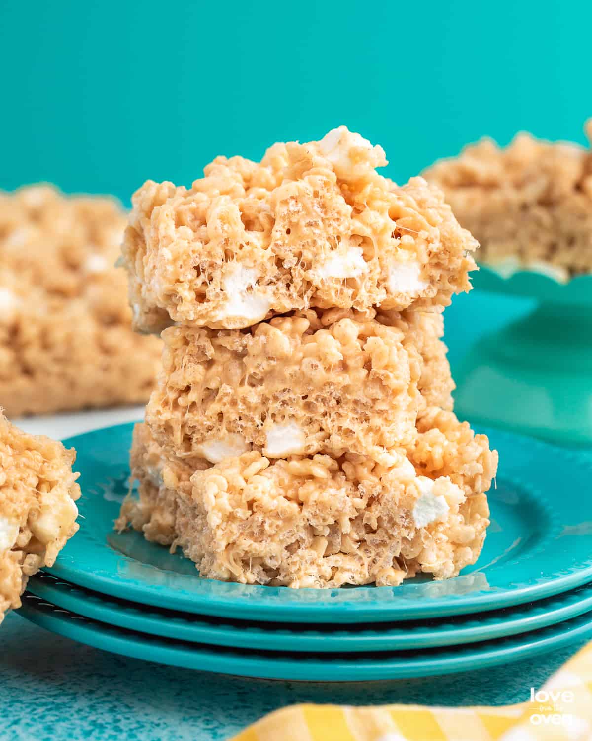 A stack of peanut butter rice krispies treats on blue plates.