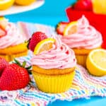 two strawberry lemon cupcakes on a blue background.