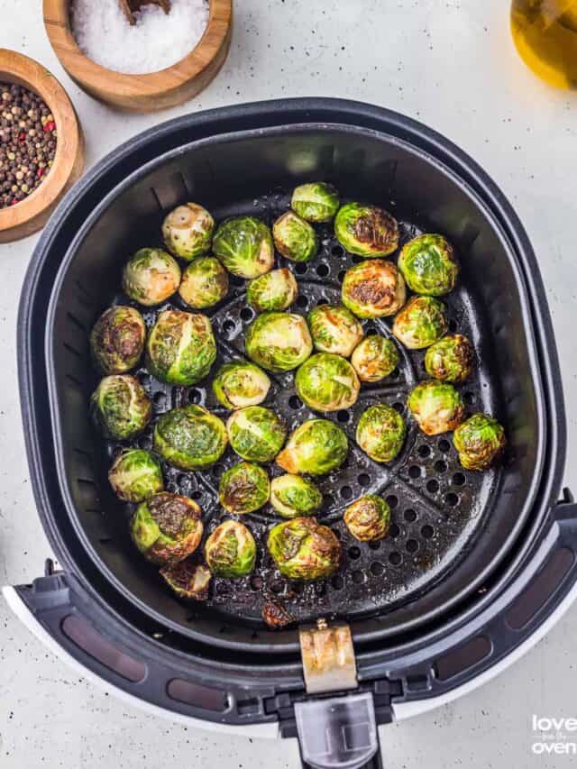 cooked brussel sprouts in an air fryer basket
