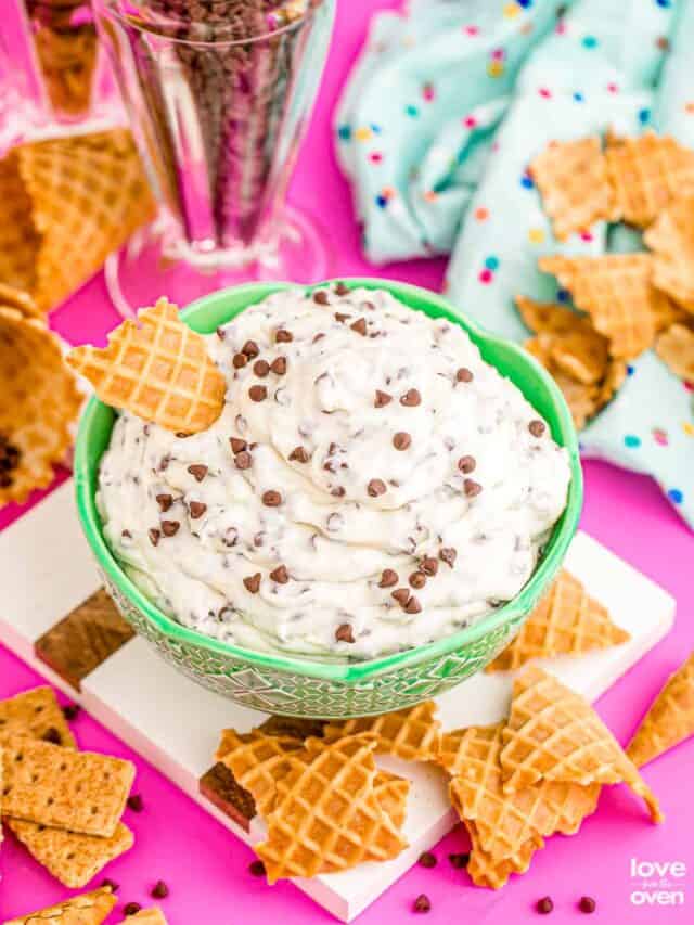 cannoli dip on a colorful table surrounded by waffle cones